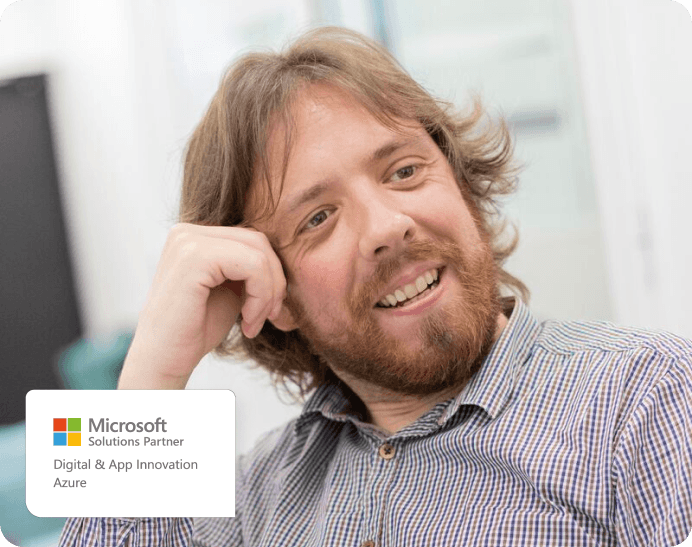 un homme souriant avec le logo de partenaire microsoft